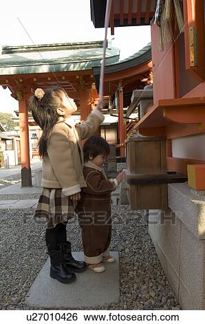 Stock Photograph - Brother and sister at shrine. Fotosearch