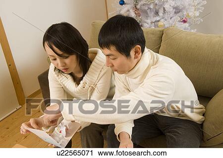 Stock Image - Couple reading Christmas card. Fotosearch