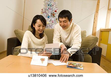 Stock Photograph - Couple reading Christmas cards. Fotosearch