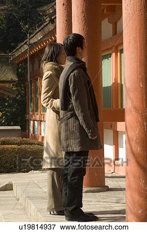 Stock Photo - Couple standing at shrine. Fotosearch