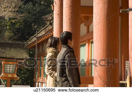 Stock Photography - Couple standing at shrine. Fotosearch