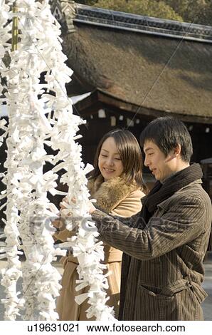 Couple tying fortune paper View Large Photo Image Stock Image - Couple tying fortune paper. Fotosearch