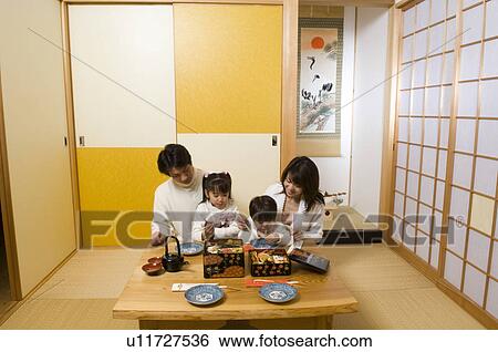 Stock Photograph - Family eating New Year's Day meal. Fotosearch