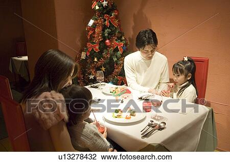 Family sitting at table View Large Photo Image Stock Image - Family sitting at table. Fotosearch