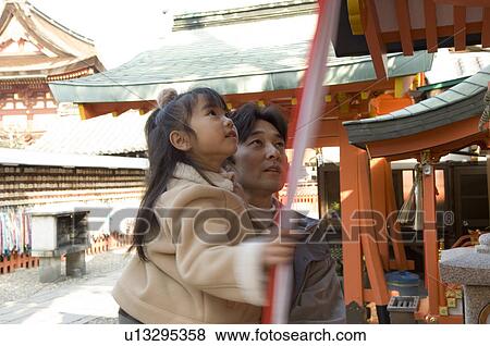 Stock Photo - Father and daughter at shrine. Fotosearch
