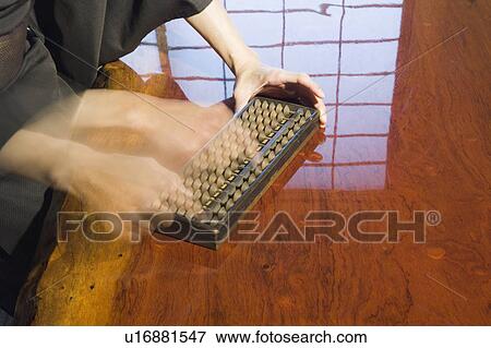 Stock Photo - Man calculating with abacus, blurred motion. Fotosearch
