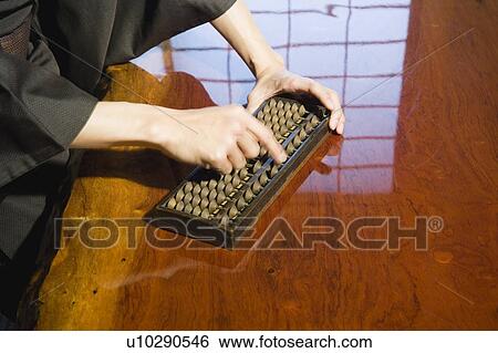 Stock Photograph - Man calculating with abacus. Fotosearch