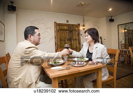 Stock Image - Mature couple dining in restaurant. Fotosearch