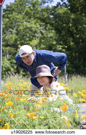 Stock Photography - Mature couple looking at flowers. Fotosearch