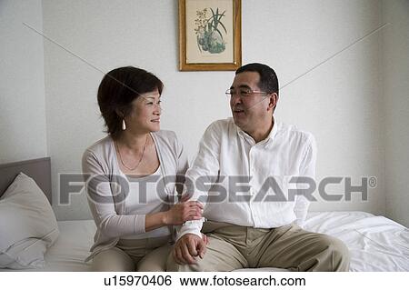 Mature couple sitting on bed View Large Photo Image Stock Photograph - Mature couple sitting on bed. Fotosearch