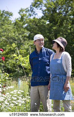 Mature couple standing in back yard View Large Photo Image Stock Image - Mature couple standing in back yard. Fotosearch