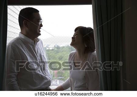 Stock Photograph - Mature couple standing on balcony. Fotosearch