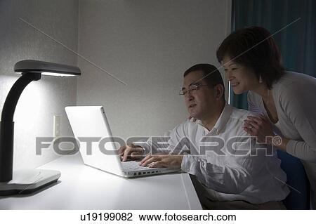 Stock Image - Mature couple using computer. Fotosearch