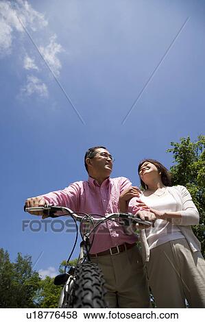 Stock Photo - Mature couple with mountain bike. Fotosearch