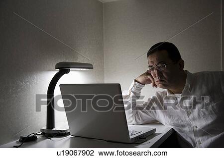 Stock Image - Mature man using computer. Fotosearch