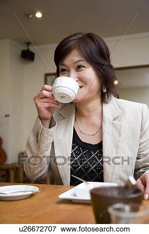 Mature woman having coffee in restaurant View Large Photo Image Stock Photo - Mature woman having coffee in restaurant. Fotosearch