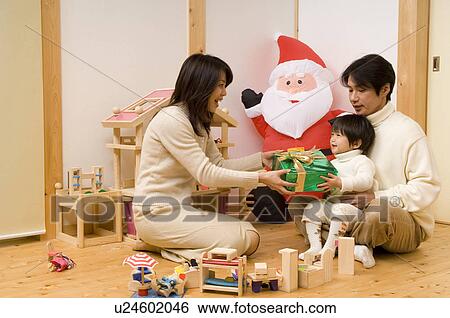 Mother giving Christmas present to son View Large Photo Image Stock Photograph - Mother giving Christmas present to son. Fotosearch