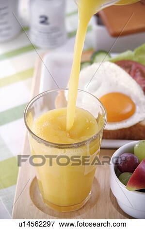 Orange juice pouring into glass View Large Photo Image Stock Photo - Orange juice pouring into glass. Fotosearch