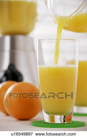 Stock Photo - Orange juice pouring into glass. Fotosearch
