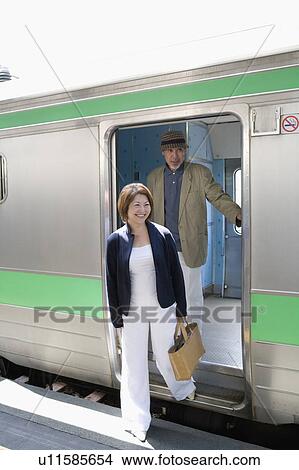 Picture - Senior couple getting off train. Fotosearch