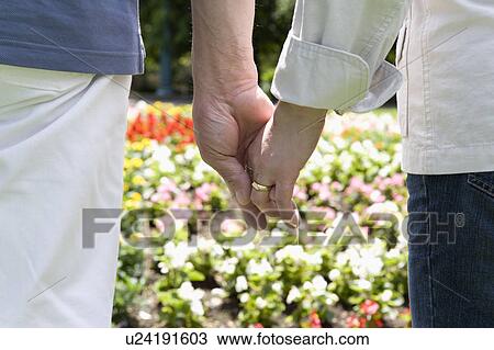 Stock Image - Senior couple holding hands. Fotosearch