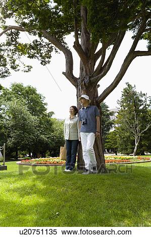 Senior couple standing under tree View Large Photo Image Stock Photography - Senior couple standing under tree. Fotosearch