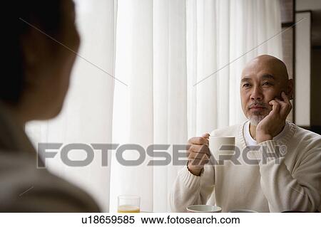 Senior man drinking coffee, senior woman in foreground View Large Photo Image Stock Photography - Senior man drinking coffee, senior woman in foreground. Fotosearch