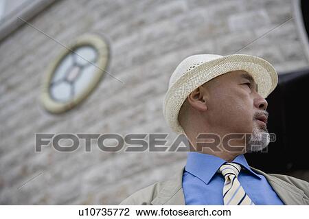 Stock Image - Senior man standing in front of building. Fotosearch