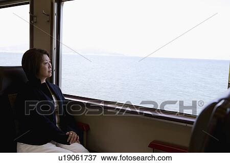 Senior woman looking out train window View Large Photo Image Stock Photo - Senior woman looking out train window. Fotosearch