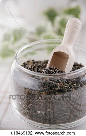 Stock Image - Tea leaves in glass jar. Fotosearch