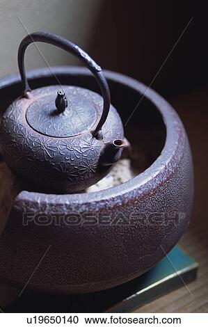 Stock Image - Tea pot on furnace. Fotosearch