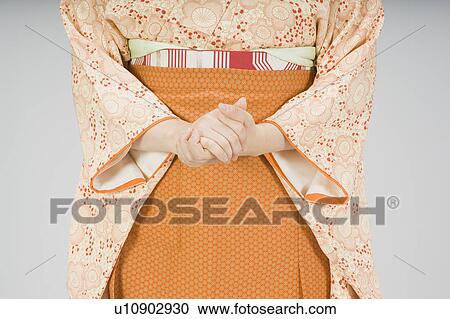 Stock Image - Woman rubbing her hands together. Fotosearch