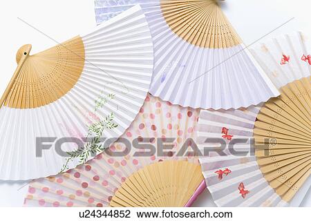 Stock Image - Four Japanese folding fans, high angle view, white background. Fotosearch