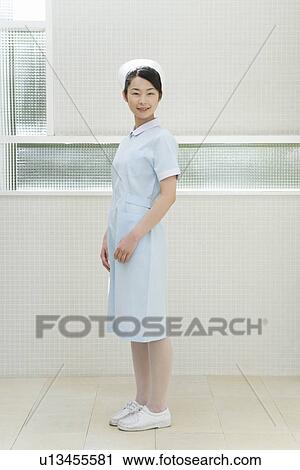 Stock Image - Portrait of a nurse, smiling and looking at camera, side view. Fotosearch