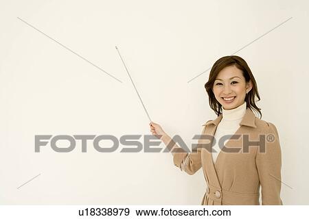 Portrait of a woman smiling and holding a pointer, looking at camera, front view, white background View Large Photo Image Stock Photo - Portrait of a woman smiling and holding a pointer, looking at camera, front view, white background. Fotosearch