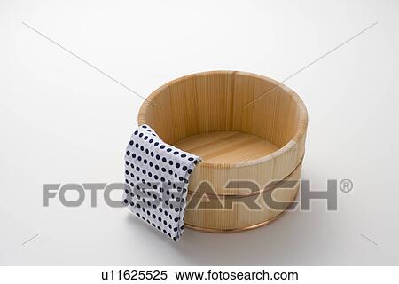 Stock Photography - Towel on a wooden tub, high angle view, white background. Fotosearch