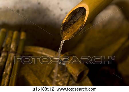 Stock Image - Water flowing from a bamboo tube, high angle view, close up, Japan. Fotosearch