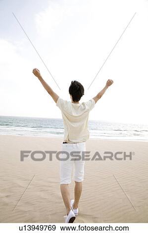 Stock Photo - Back figure of man at the beach. Fotosearch