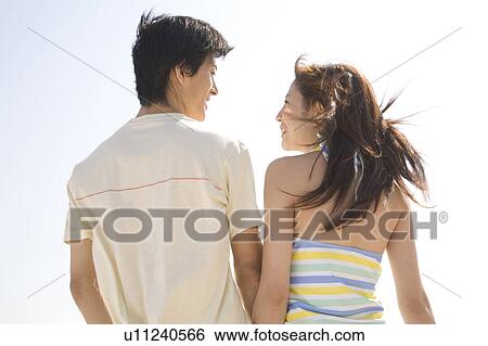 Stock Photograph - Back figure of young couple. Fotosearch