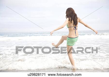 Stock Image - Back of young woman in swimsuit. Fotosearch