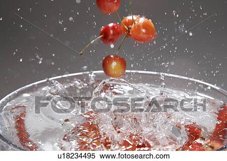 Stock Photography - Cherries plunging into water. Fotosearch