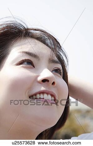Close-up of young woman smiling View Large Photo Image Stock Photo - Close-up of young woman smiling. Fotosearch