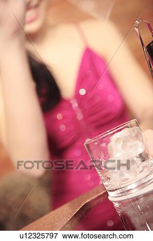 Stock Photo - Close-up on a glass in a nightclub. Fotosearch