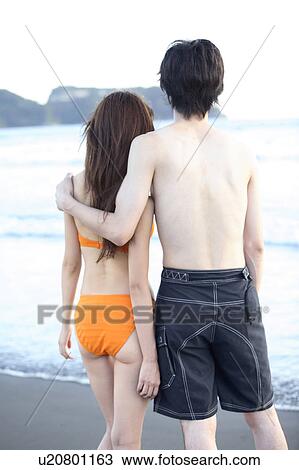 Stock Image - Couple at Enoshima beach. Fotosearch