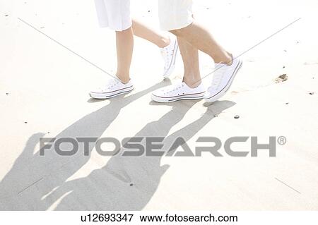 Feet of couple walking on a beach View Large Photo Image Stock Photo - Feet of couple walking on a beach. Fotosearch