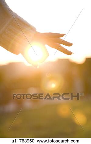 Stock Image - Finger encircling sun. Fotosearch