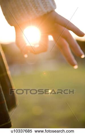 Stock Photography - Finger encircling sun. Fotosearch