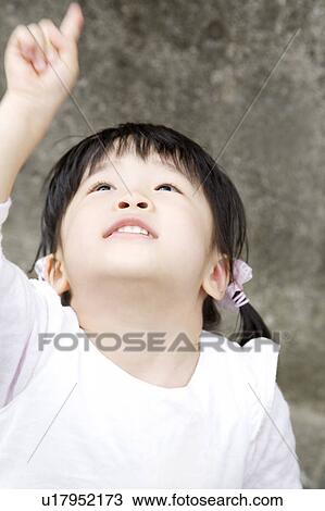 Stock Image - Girl looking up in the sky. Fotosearch
