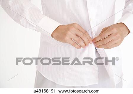 Hand of a man fastening the button of the shirt View Large Photo Image Stock Image - Hand of a man fastening the button of the shirt. Fotosearch
