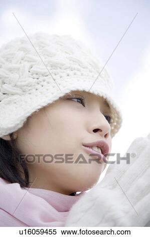Stock Photography - Low angle portrait of a woman wearing a hat, scarf, and gloves. Fotosearch